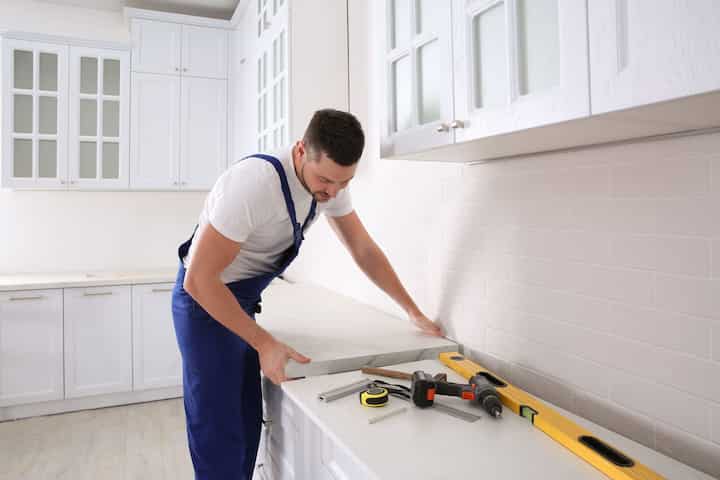 A professional kitchen remodeling contractor working on countertops in St. Charles, Illinois home.